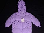 A girls' purple hooded polyester jacket, featuring a quilted design and butterfly-shaped details on the front, lying on a flat surface.