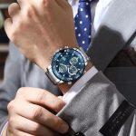 A man in a grey suit wearing the POEDAGAR E102 Digital Watch with a silver stainless steel band and a blue dial.