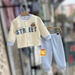 Baby cartoon velvet thermal base layer set in cream and light blue hanging on a wooden hanger.
