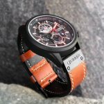 A CURREN 8380 chronograph men's watch with a brown leather strap and rose gold details, displayed on a dark textured surface.