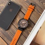 A CURREN 8380 chronograph men's watch with a brown leather strap and rose gold details, displayed on a dark textured surface.