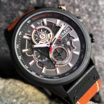 A CURREN 8380 chronograph men's watch with a brown leather strap and rose gold details, displayed on a dark textured surface.