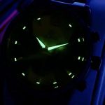 Close-up of the OLEVS 3645 Wood & Steel Moon Phase Chronograph with its luminous hands and markers glowing in the dark.