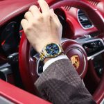 A man wearing the POEDAGAR 688 Luxury Business Man Wristwatch with a blue dial and two-tone bracelet inside a luxury car.