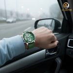 A man wearing the POEDAGAR E108 analog-digital watch with a green dial and strap while driving a car on a foggy day.