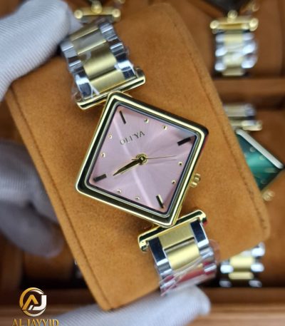 A gloved hand holding the OLIYA 6819 women's two-tone watch, showing its pink square dial and gold and silver-tone bracelet.