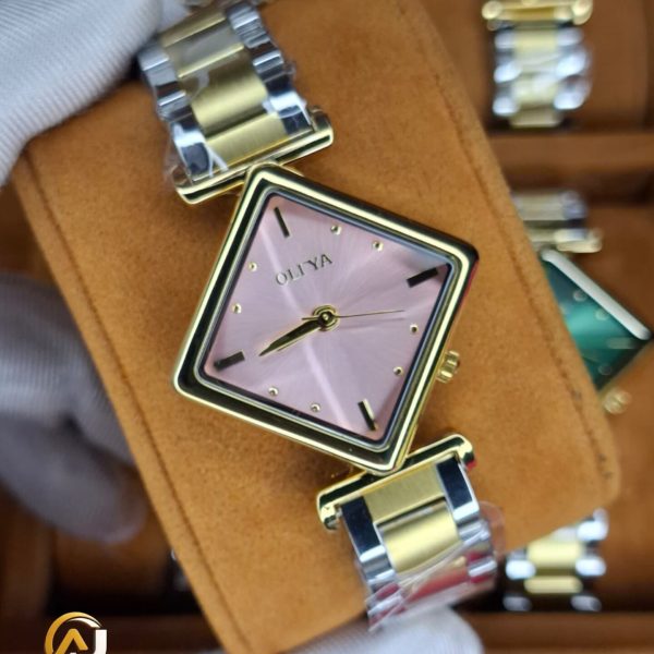 A gloved hand holding the OLIYA 6819 women's two-tone watch, showing its pink square dial and gold and silver-tone bracelet.