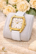 A Curren 9113 women's watch with a gold square case, a white textured dial, and a white silicone strap on a display cushion.