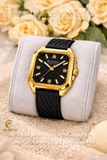 A Curren 9113 Women's Square Silicone Watch with a gold case and black dial, displayed on a cushion placed on sand.