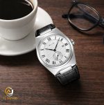 A SKMEI 9390 Roman Dial Leather Watch with a silver case and white dial, resting on a wooden table next to a cup of coffee.