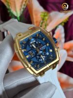 A gloved hand holding a CURREN 8488 men's watch, featuring a gold-tone case, blue chronograph dial, and a white strap.