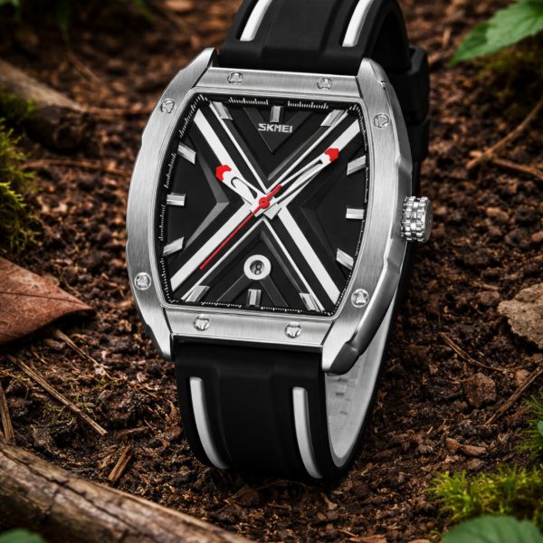 A SKMEI 9364 Men's Luminous Hollow Watch with a black and white X-pattern dial, resting on a bed of forest soil and leaves.