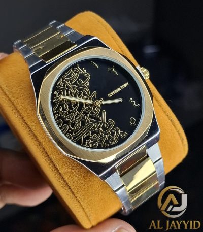 A Universe Point Arabic Calligraphy Watch with a two-tone gold and silver band, held on a yellow cushion to show the black dial.