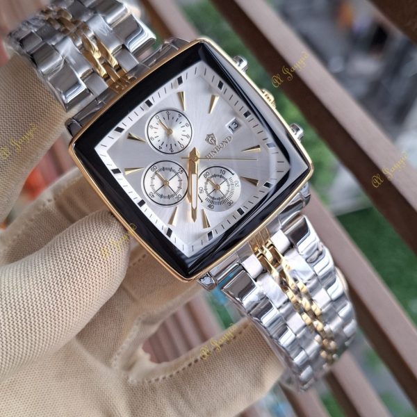 A gloved hand holding the Binbond 911 Original Men's Luxury Watch, showing its two-tone silver and gold metal bracelet.
