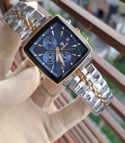 A gloved hand holds the Binbond 911 men's watch, showing its blue square dial and two-tone silver and gold bracelet.