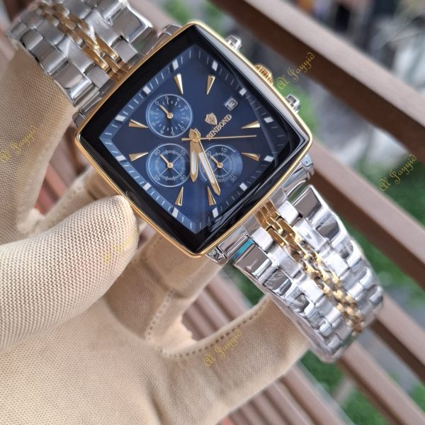 A gloved hand holds the Binbond 911 men's watch, showing its blue square dial and two-tone silver and gold bracelet.