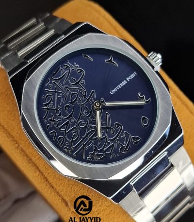 A close-up of the Universe Point watch featuring a silver case and band with a dark blue dial decorated with Arabic calligraphy.