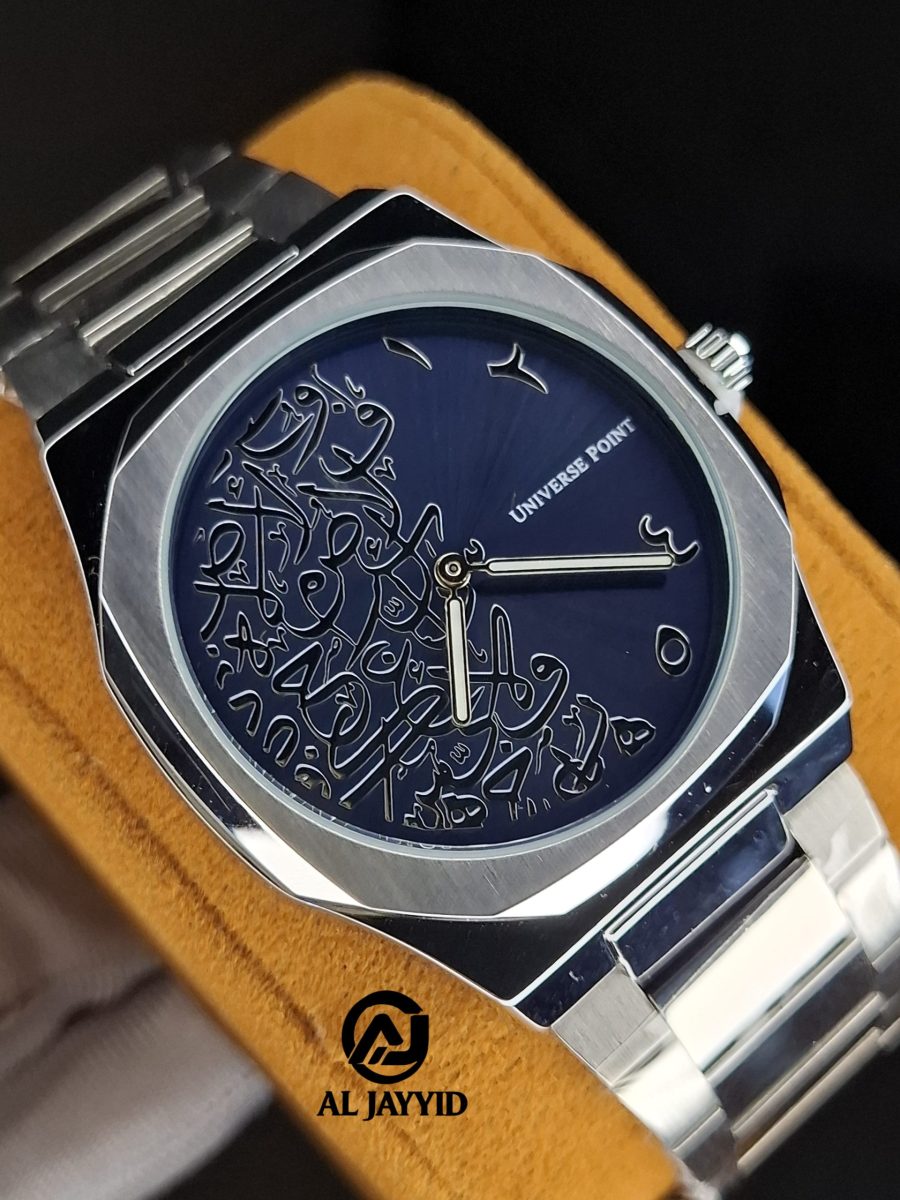 A close-up of the Universe Point watch featuring a silver case and band with a dark blue dial decorated with Arabic calligraphy.