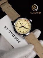 A gloved hand holding the POEDAGAR 895 men's watch with a beige leather strap and a textured cream dial.