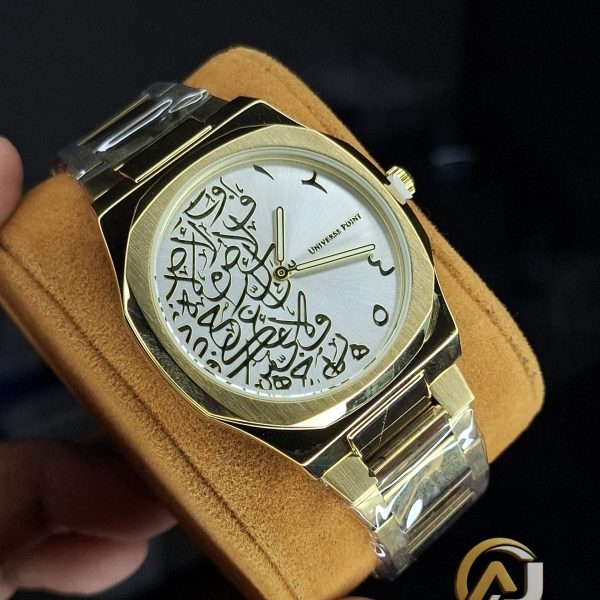 A close-up of the Universe Point Arabic Calligraphy Watch, showing its gold case and silver dial with black calligraphy.
