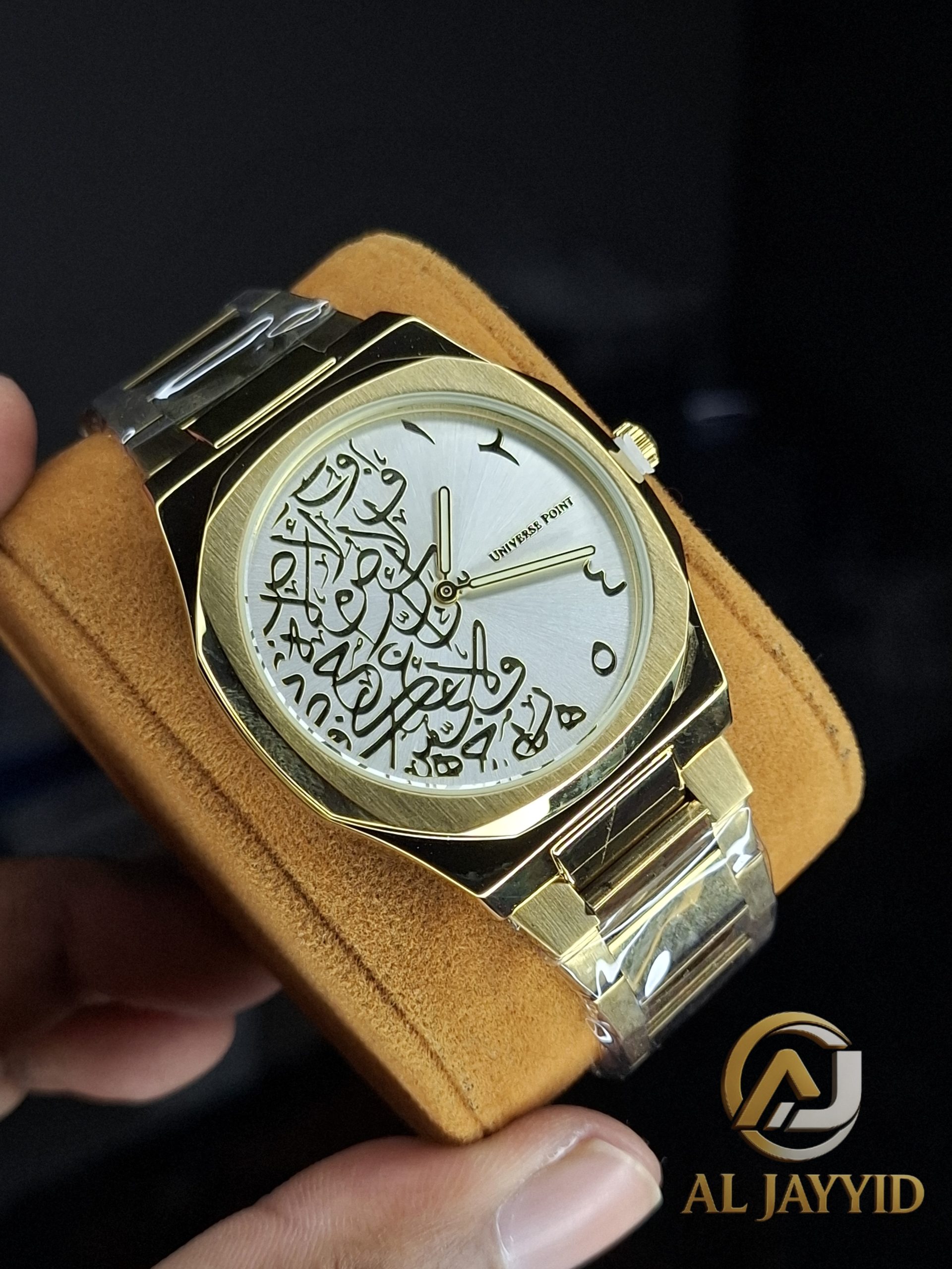 A close-up of the Universe Point Arabic Calligraphy Watch, showing its gold case and silver dial with black calligraphy.