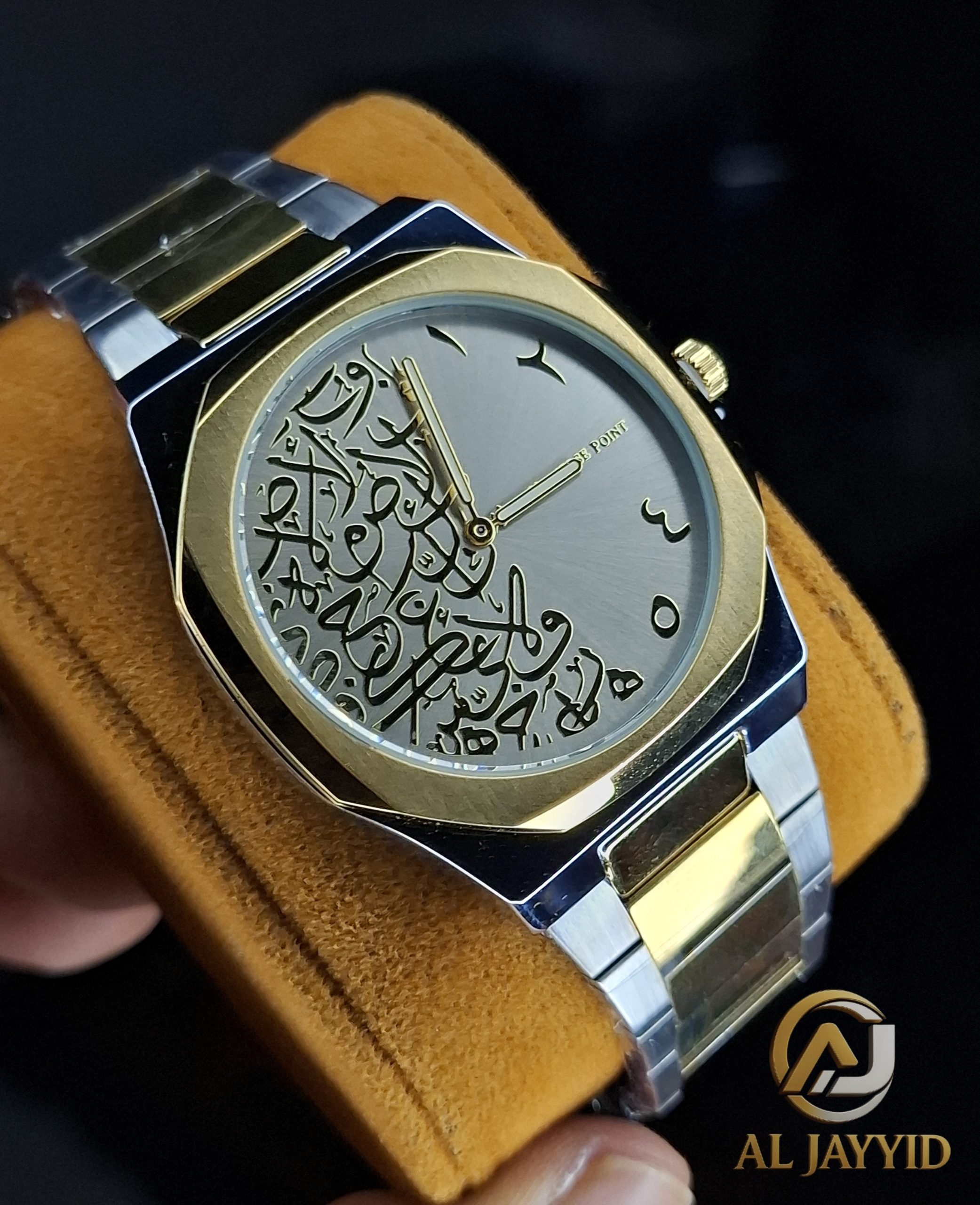 Close-up of the Universe Point Arabic Calligraphy Watch with its two-tone metal band resting on a brown cushion.