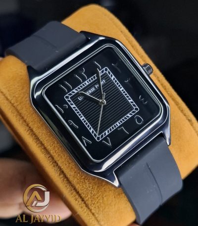 A Universe Point black silicone watch with a square face and Arabic numerals, shown at an angle on a yellow surface.