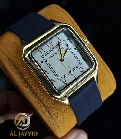 A close-up of the Universe Point watch, showing its square gold-tone case, white dial with Arabic numerals, and dark silicone strap.