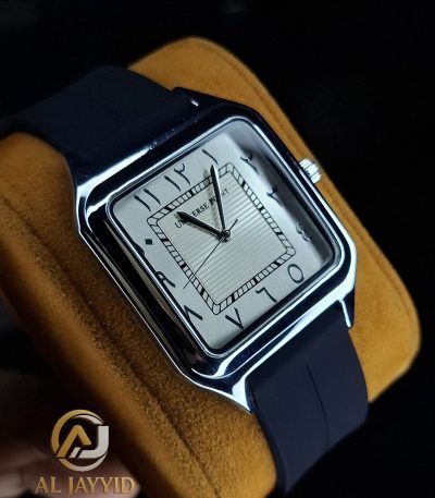 A Universe Point Watch with a square silver case and a textured white dial with Arabic numerals, shown on a yellow cushion.