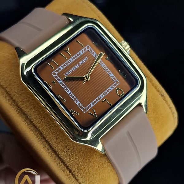 A close-up of the Universe Point Watch, featuring a square gold-tone case, a brown dial with Arabic numerals, and a beige silicone strap.