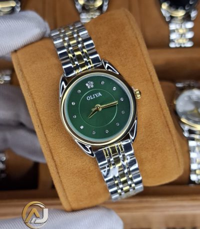 A gloved hand holding an OLIYA 6658 women's watch with a green dial and a two-tone silver and gold band.