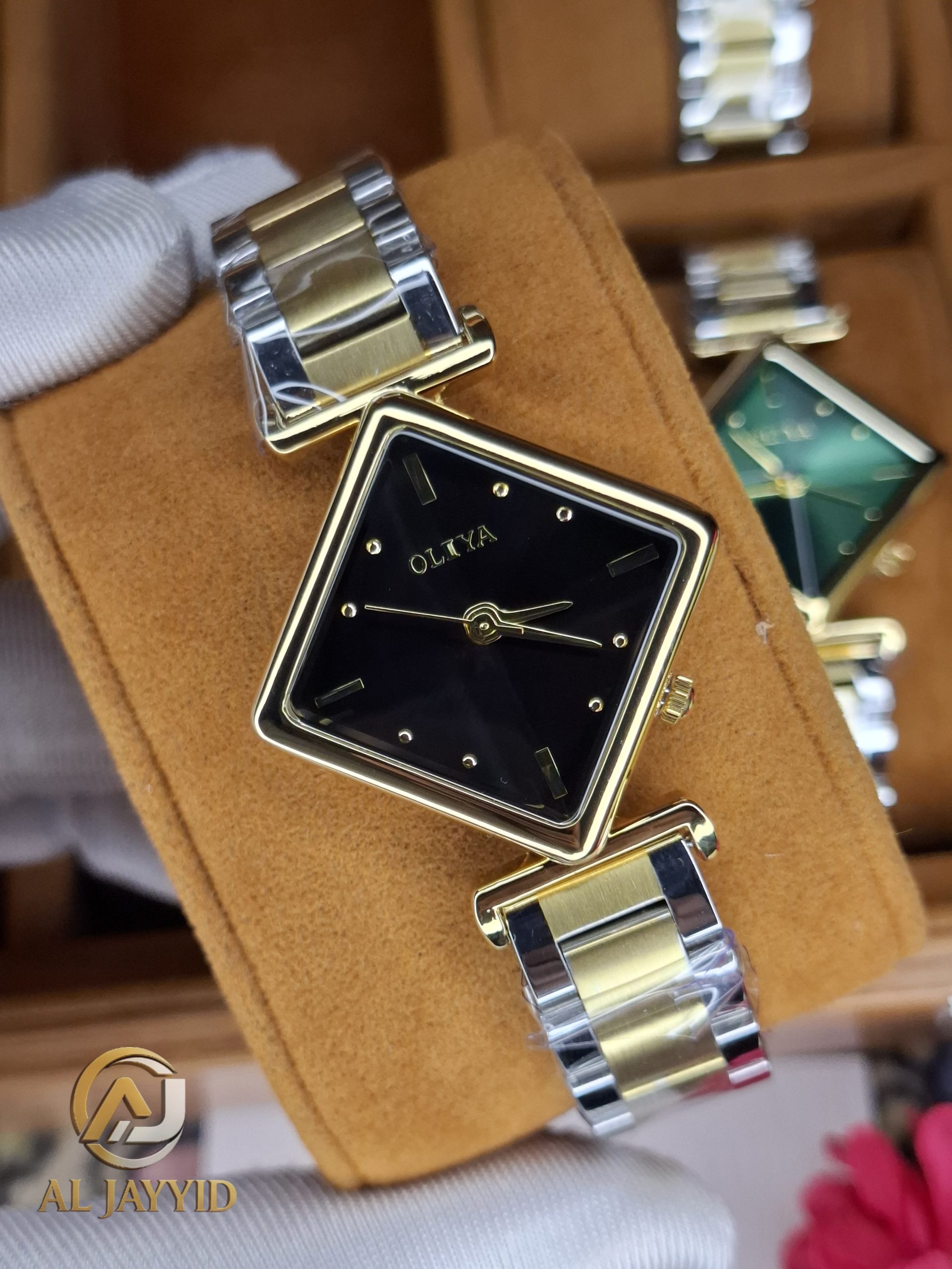 Close-up of the OLIYA 6819 women's watch, featuring a square black dial, gold-tone case, and a two-tone metal bracelet.