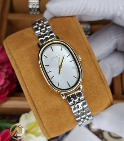 A gloved hand holding the OLIYA 2015 women's two-tone watch, showing its oval gold case and silver and gold link bracelet.