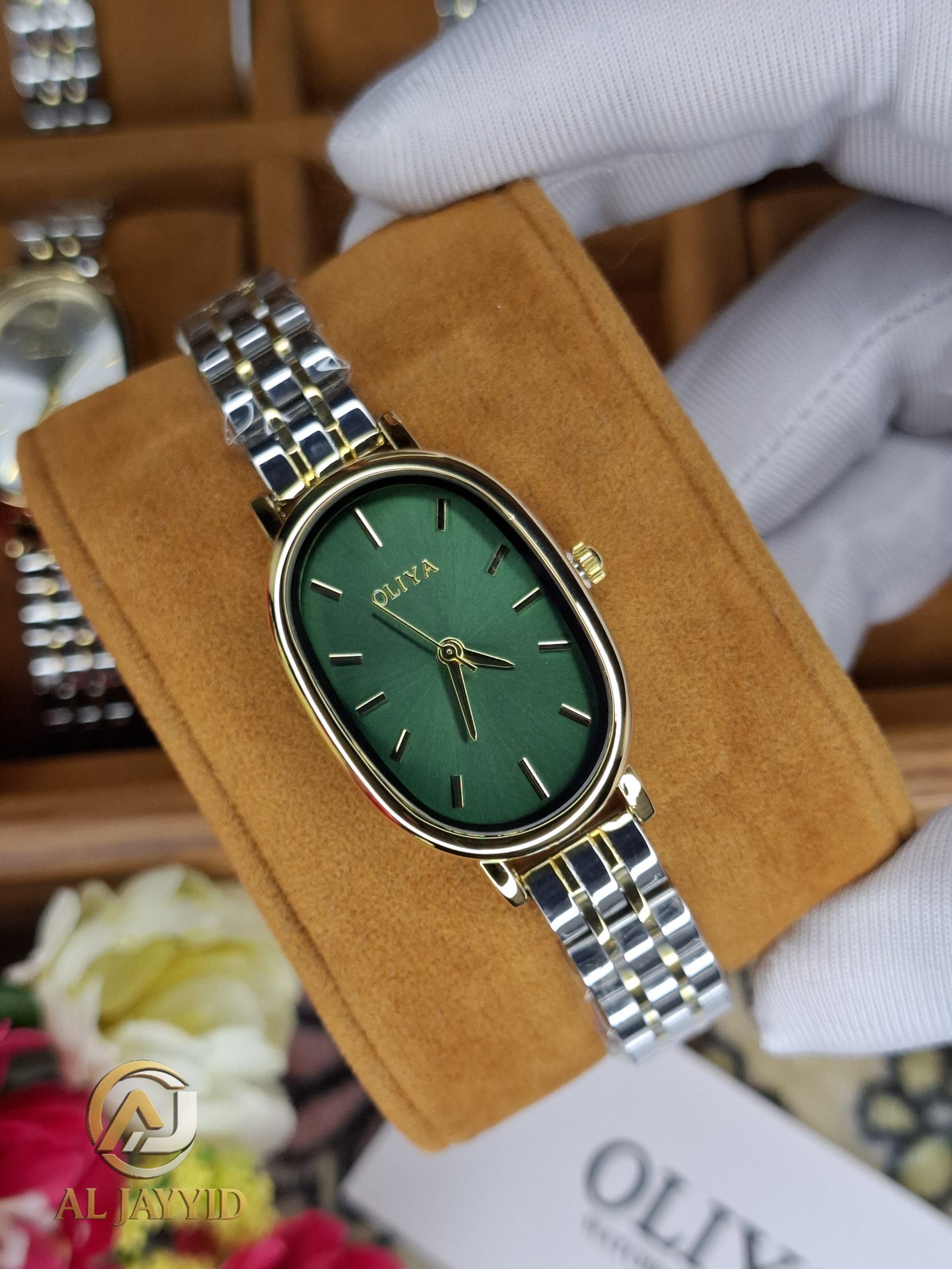 OLIYA 2015 women's watch with a green oval face, gold case, and a two-tone gold and silver metal link bracelet.