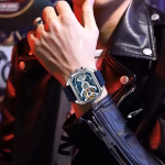 A man wearing a POEDAGAR E106 dual display watch with a blue silicone strap and a silver-tone case on his wrist.