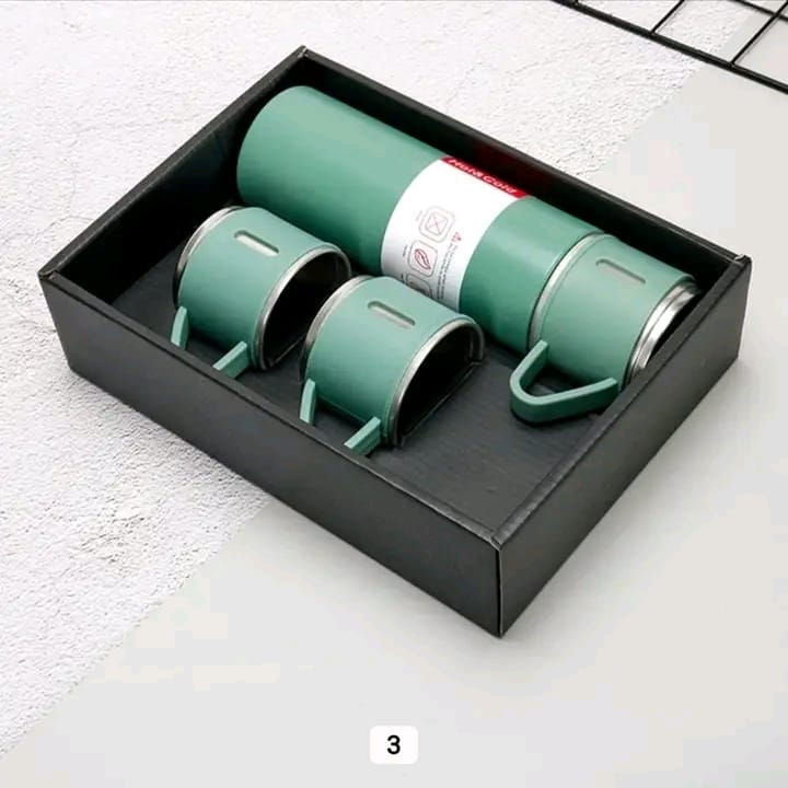 A green vacuum flask set with three matching cups neatly arranged inside a black presentation box.