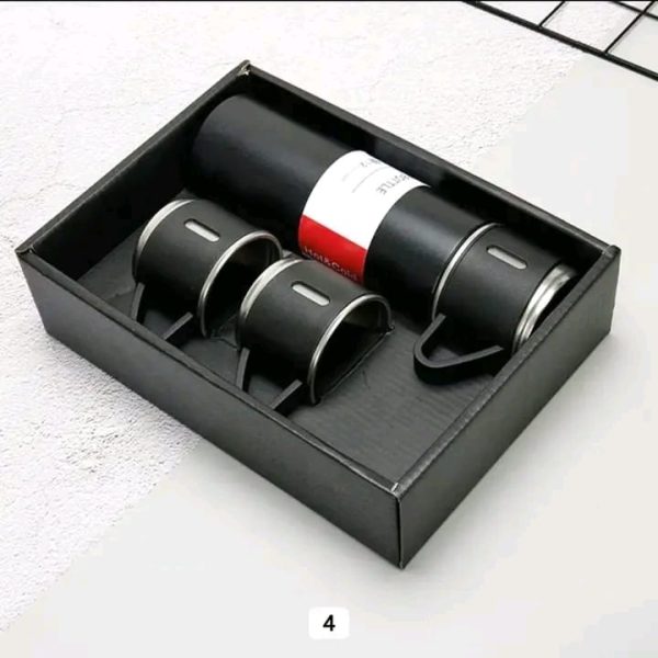A black Vacuum Flask Set with matching cups displayed neatly inside its presentation box.