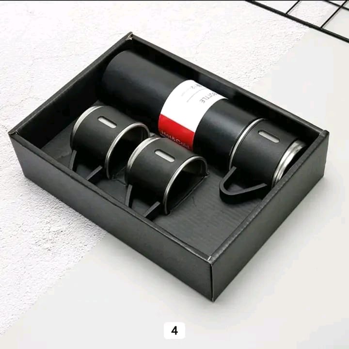 A black Vacuum Flask Set with matching cups displayed neatly inside its presentation box.