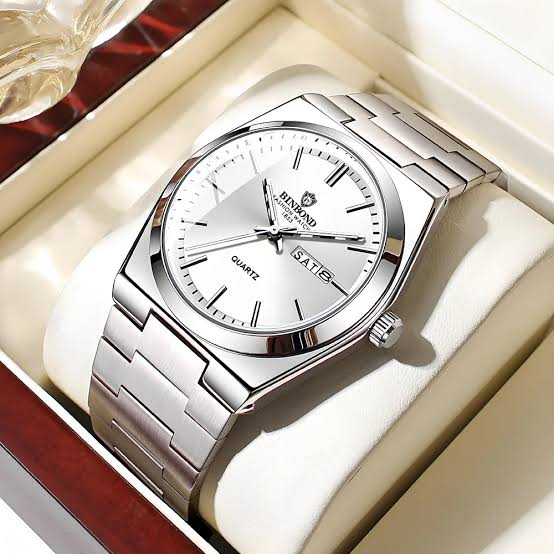 A BINBOND 102 luxury men's wrist watch with a silver-colored steel case and bracelet, resting in its display box.