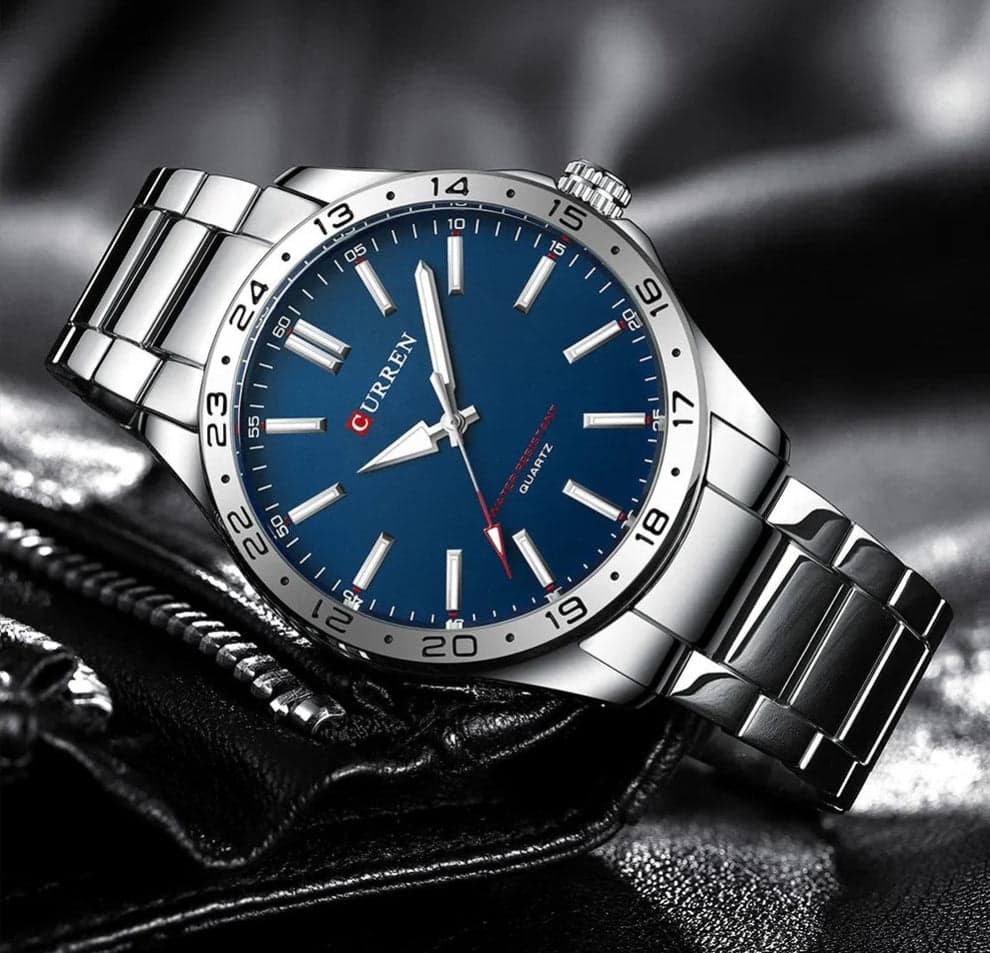 A silver-tone Curren 8452 quartz watch for men, featuring a striking blue dial and a metal link bracelet.