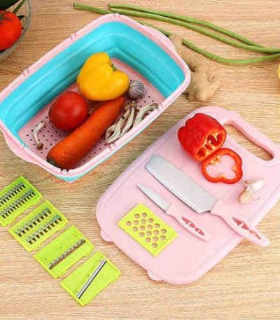 A Multi Functional Slitting Planer set with a pink cutting board, collapsible colander, knives, and various blades on a wooden table.