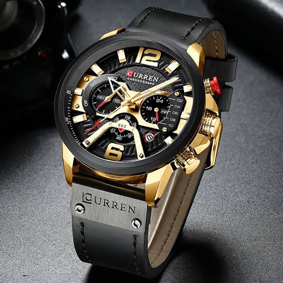 A close-up view of the CURREN 8329 sport watch, highlighting its black and gold chronograph dial and black leather strap.