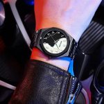 A person wearing the black Bestwin 812 watch with its unique black and white face featuring Arabic numerals.