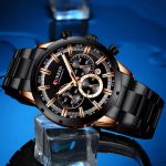 A black and rose gold CURREN 8355 chronograph watch with a stainless steel band resting on an ice cube against a blue background.