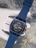 A person wearing a white glove holds the CURREN 8442 men's watch, showing its blue silicone band and rose gold case with a blue chronograph face.