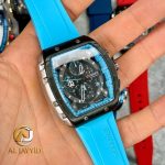 A hand holding the CURREN 8442 chronograph men's watch, which features a sky blue silicone band and a black multi-function dial.