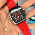 A hand holding the CURREN 8442 men's chronograph quartz watch, featuring a black case, red subdials, and a red silicone strap.