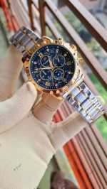 A gloved hand holding a POEDAGAR 973 luxury sports watch with a silver and gold band and a black, starry dial.