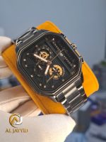 A gloved hand holding a Poedagar 628 men's watch. The watch has a black stainless steel strap and a black dial with gold accents.