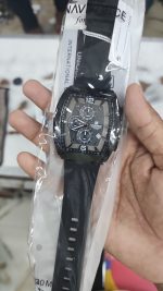 A hand holding a Naviforce NF6101 men's watch in its clear packaging.